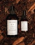 Two bottles of Fable & Rune hand sanitizer surrounded by cinnamon sticks and star anise.