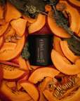 Black candle on a decorative wreath made of sliced pumpkins