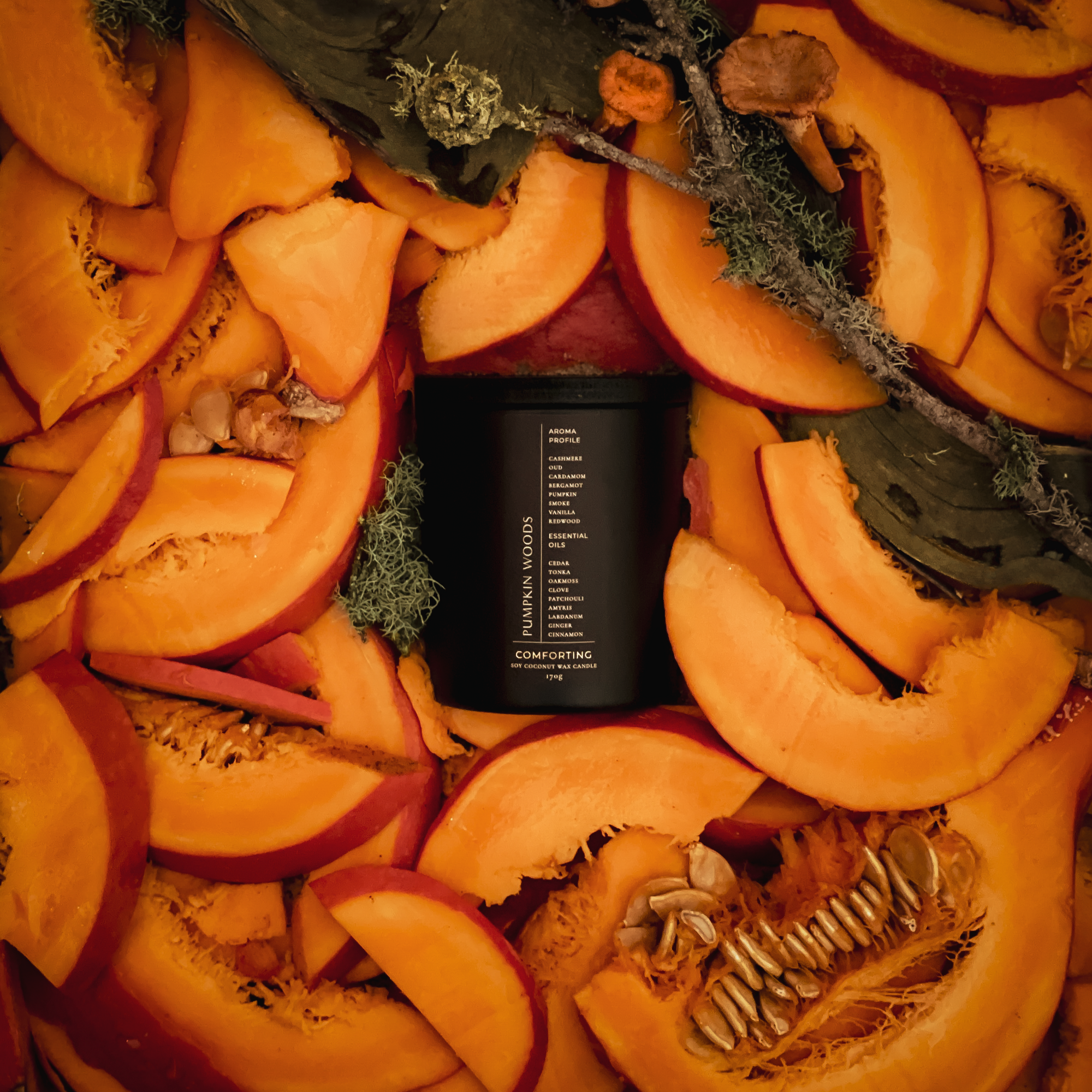 Black candle on a decorative wreath made of sliced pumpkins