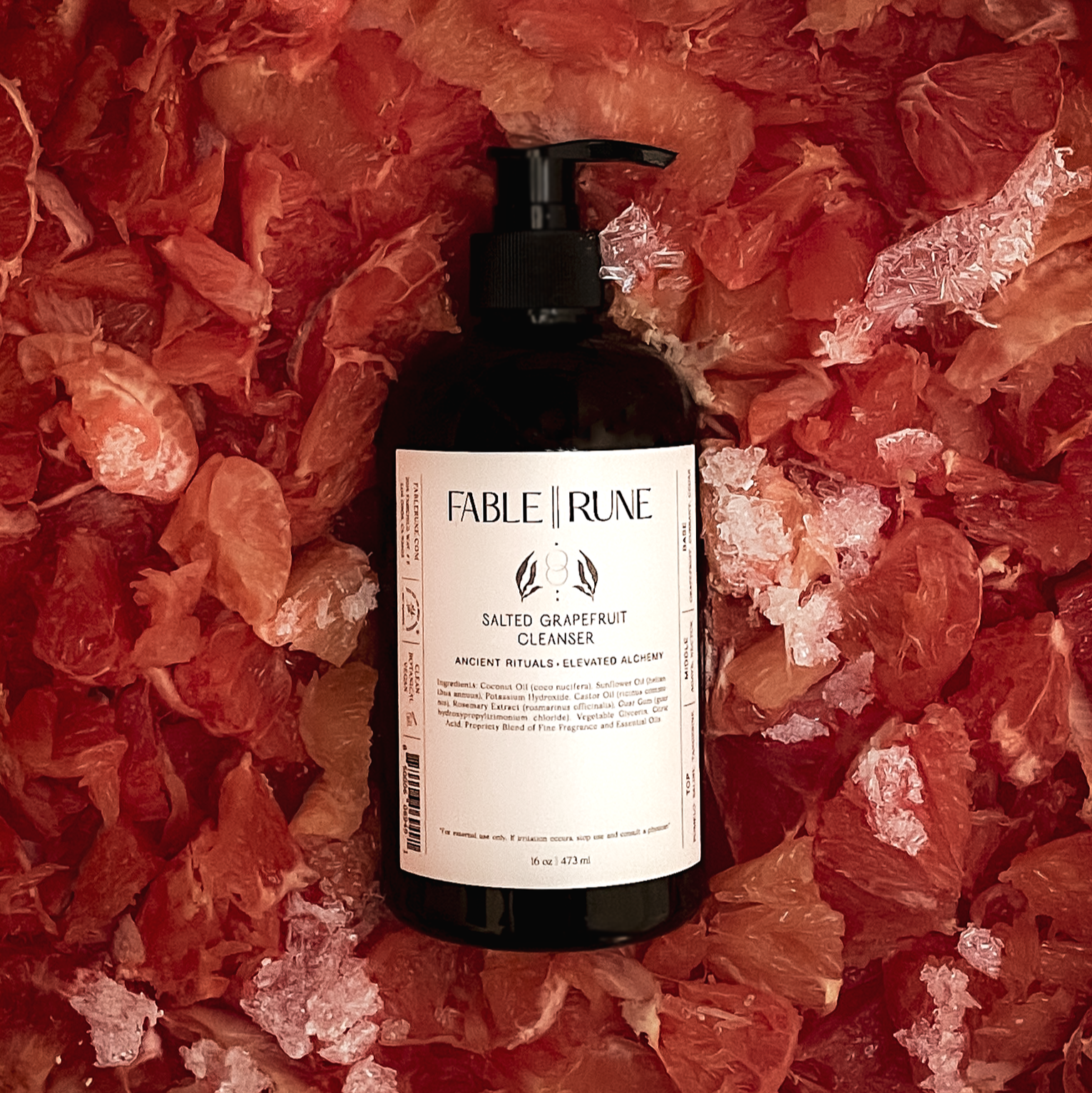 Bottle of body cleanser soap on a bed of grapefruit and sea salt