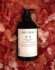 Bottle of body cleanser soap on a bed of grapefruit and sea salt
