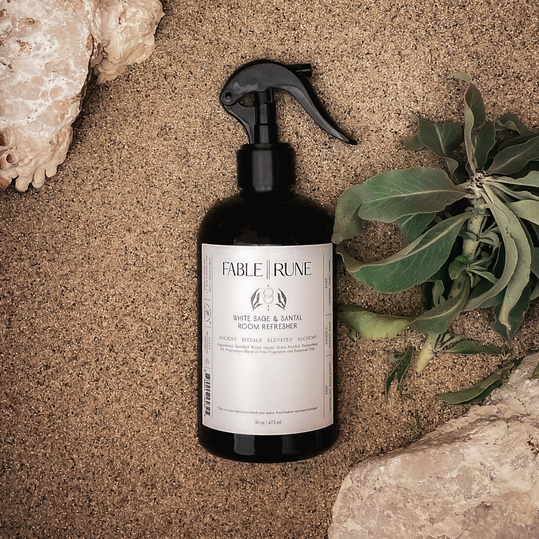 Fable & Rune bottle on sand with leaves and shell