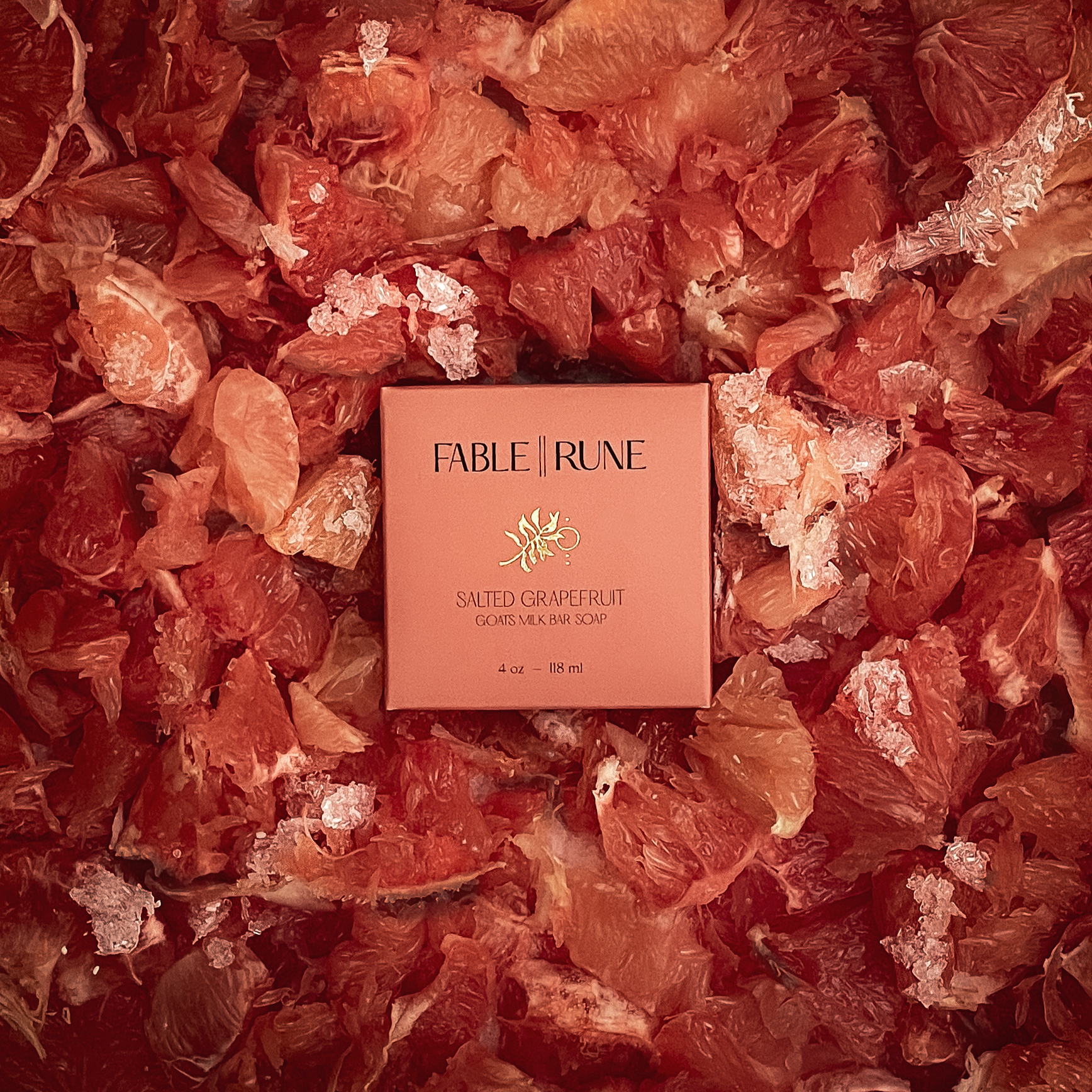 Salted grapefruit bar soap surrounded by dried grapefruit pieces.